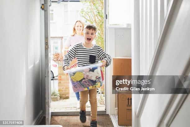 young boy and mother walking into new home - family smiling at front door stock pictures, royalty-free photos & images