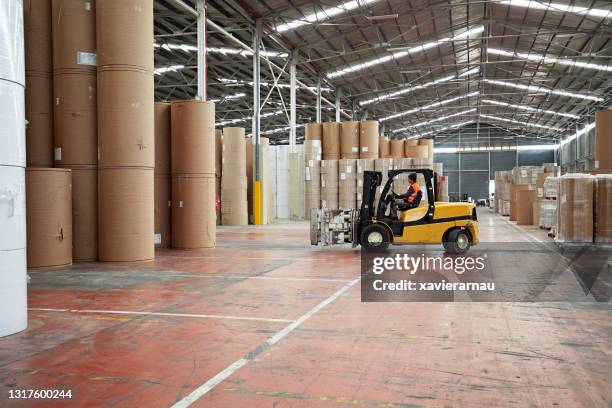 caucasian male worker driving forklift in warehouse - ware house worker forklift stock pictures, royalty-free photos & images