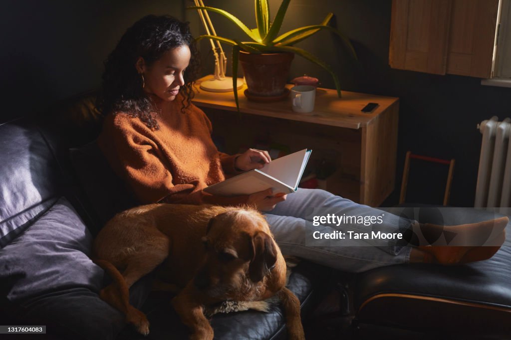 Woman sitting on sofa reading