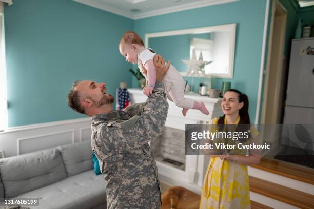 happy military family enjoying in time together at home. - national guard stock pictures, royalty-free photos & images