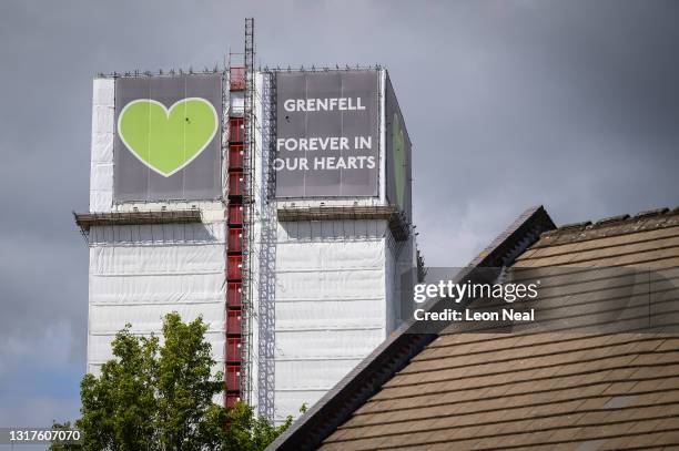 The covered structure of Grenfell Tower is seen above a nearby housing estate on May 12, 2021 in London, England. The Ministry of Housing Communities...