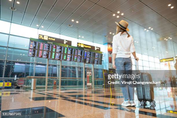 rear tourist woman at international airport - flughafen stock-fotos und bilder