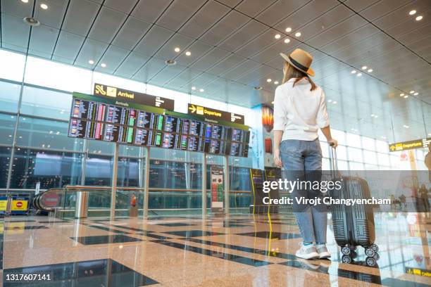 rear tourist woman at international airport - airport imagens e fotografias de stock