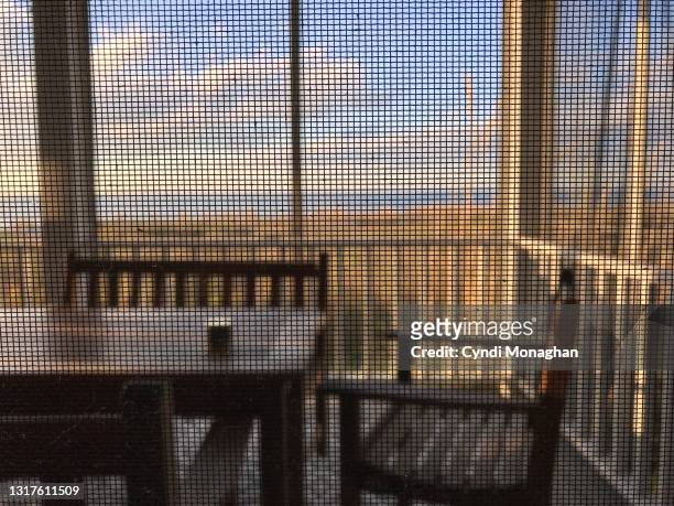 view through a screen window to a porch looking out over the chesapeake bay - glass door stock pictures, royalty-free photos & images