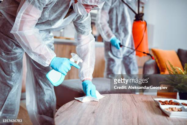 medical workers focused on home sanitizing after transporting patients to hospital - infection control stock pictures, royalty-free photos & images
