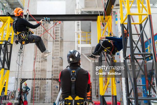 werken bij hoogtetrainingscentrum - safety harness stockfoto's en -beelden