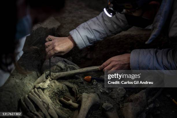 Forensic archaeologist Inma Lopez holds one of the bone of the arms during the exhumation process of the remains of a victim, shot in the head during...