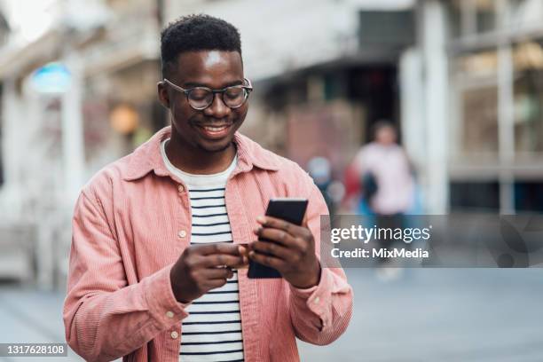 porträt eines glücklichen jungen mannes, der online mit einer kreditkarte bezahlt - phone charging stock-fotos und bilder