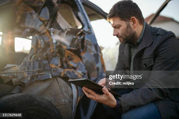 car insurance agent at work by the crashed car - car insurance agent stock pictures, royalty-free photos & images