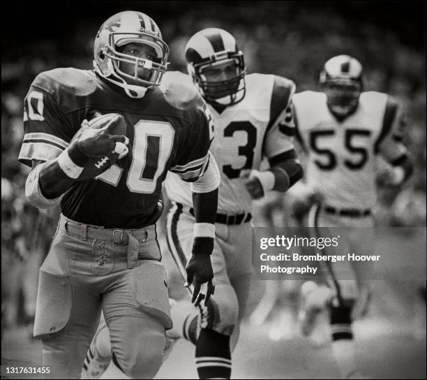 View of American football player Billy Sims, of the Detroit Lions, runs with the ball during a game against the Los Angeles Rams at Anaheim Stadium,...