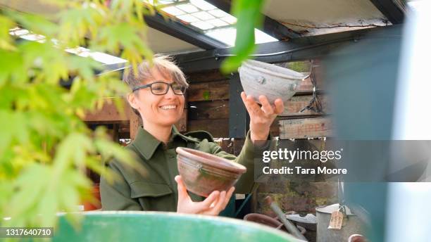 woman comparing plant pots in plant nursery - comparison shop stock pictures, royalty-free photos & images