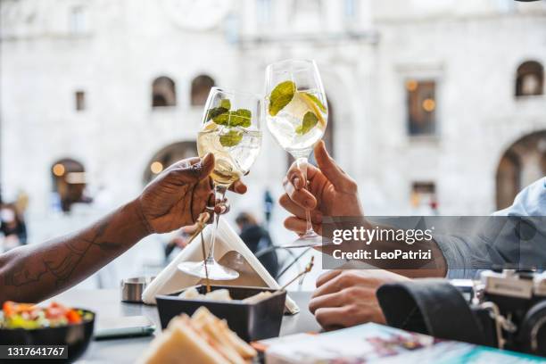 touristenpaar sitzt in einem café und nimmt einen aperitif zur happy hour - aperitif stock-fotos und bilder