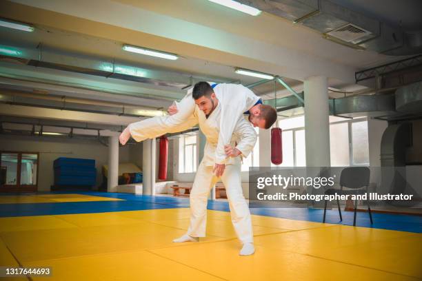 two young judo fighters in kimono training martial arts in the gym with expression, in action and motion - yellow belt stock pictures, royalty-free photos & images