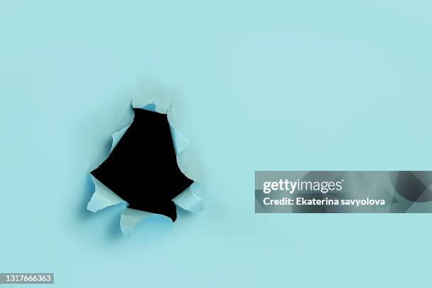 torn paper background. a hole in the paper on a black background. place for the label. - breaking boundaries stock pictures, royalty-free photos & images
