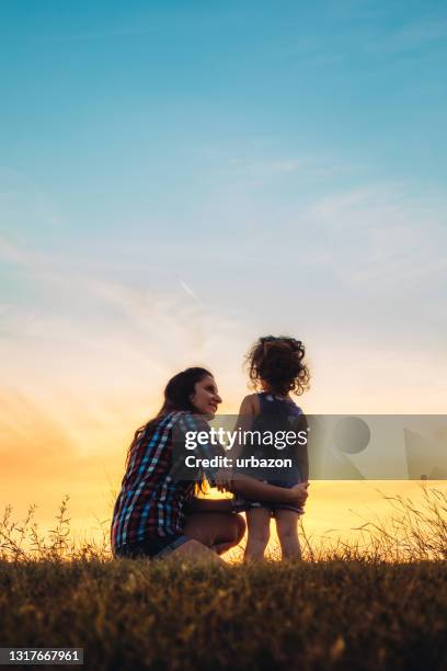 mother and daughter embracing at sunset - family concept stock pictures, royalty-free photos & images