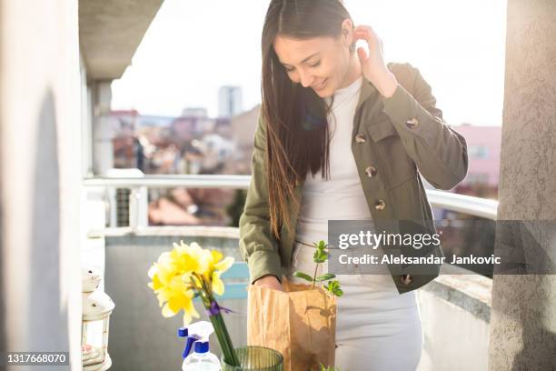 a happy young woman decorating her balcony with plants - daffodil isolated stock pictures, royalty-free photos & images