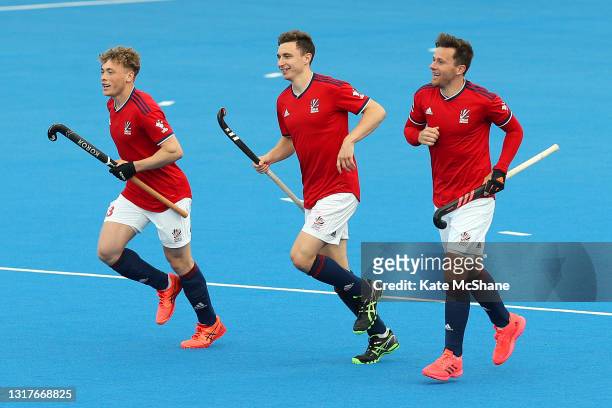 Harry Martin of Great Britain celebrates scoring their team's fifth goal with team mates Jacob Draper and Alan Forsyth during the FIH Hockey Pro...