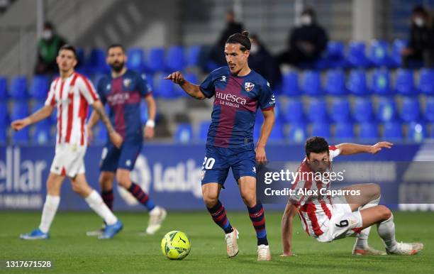 Jaime Seoane of SD Huesca runs with the ball whilst under pressure from Mikel Vesga of Athletic Club during the La Liga Santander match between SD...