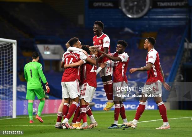 Emile Smith Rowe of Arsenal celebrates with team mates after scoring their side's first goal during the Premier League match between Chelsea and...
