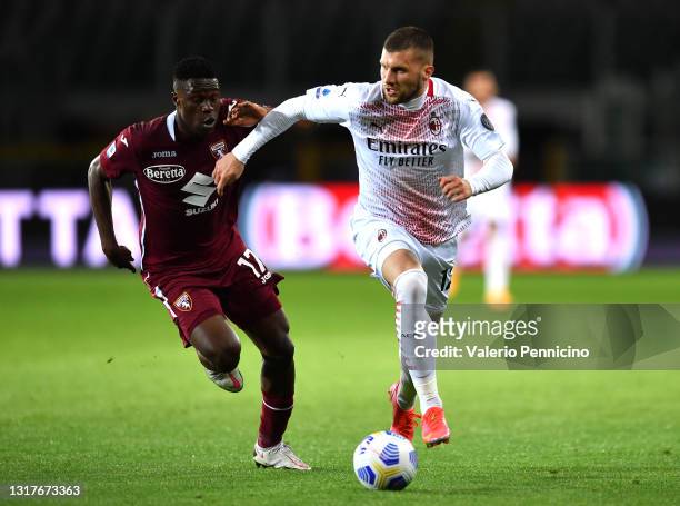 Ante Rebic of A.C. Milan battles for possession with Wilfried Singo of Torino FC during the Serie A match between Torino FC and AC Milan at Stadio...