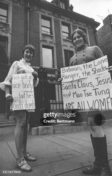 Nancy Moore and Jody Parsons, of the Chicago Women's Liberation Union hold signs as they parade in front of the mansion belonging to Playboy Magazine...