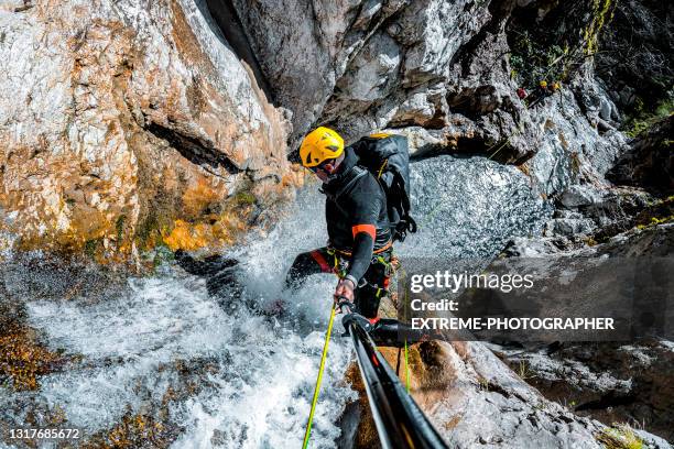 canyoneer abseilen langs de waterval - canyon stockfoto's en -beelden