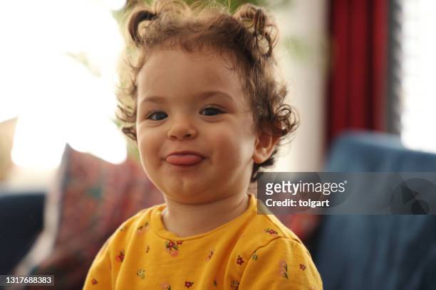 baby girl smiles fervently and sticks out her tongue - funny baby faces stock pictures, royalty-free photos & images