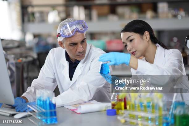 two scientist doing chemical experiment and record the experimental results in compute - drug development stock pictures, royalty-free photos & images