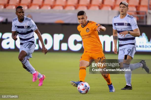 Matias Vera of Houston Dynamo controls the ball ahead of Alan Pulido of Sporting Kansas City during the first half at BBVA Stadium on May 12, 2021 in...