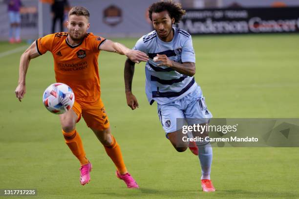 Gianluca Busio of Sporting Kansas City chases for the ball alongside Adam Lundqvist of Houston Dynamo during the first half at BBVA Stadium on May...