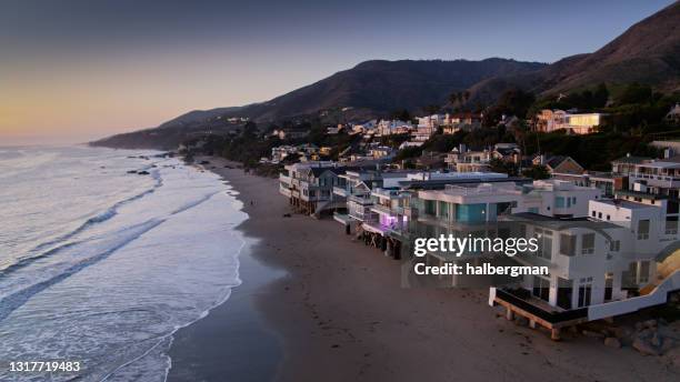 strandhäuser in malibu bei sonnenuntergang - luft - haus malibu stock-fotos und bilder
