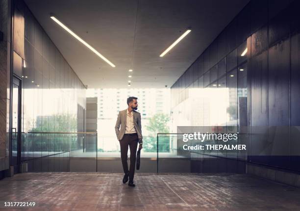 latin businessman walking on a office building lobby - career path stock pictures, royalty-free photos & images