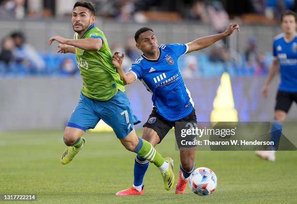 Fighting for control of the ball Marcos Lopez of San Jose Earthquakes collides with Cristian Roldan of Seattle Sounders during the first half of...