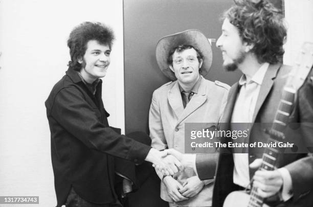 American blues and rock guitarist Michael Bloomfield, folk singer songwriter Ramblin' Jack Elliott, and singer songwriter Bob Dylan meet up backstage...