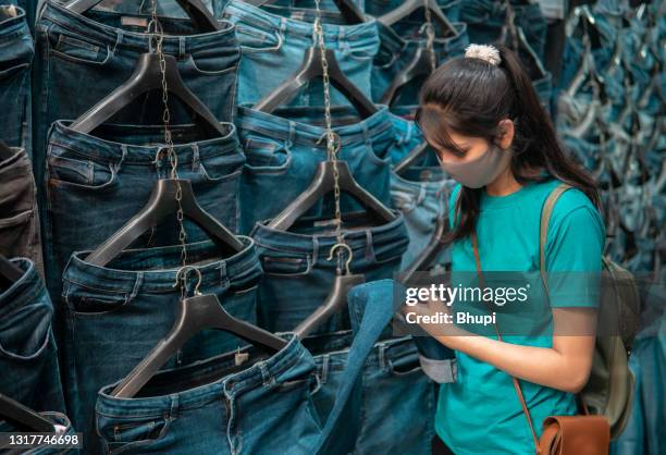 indian young woman shopping for jeans. - delhi street stock pictures, royalty-free photos & images