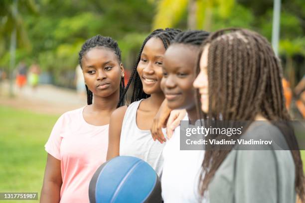 vier tienervrienden gelukkig om mand samen te spelen - women's basketball stockfoto's en -beelden