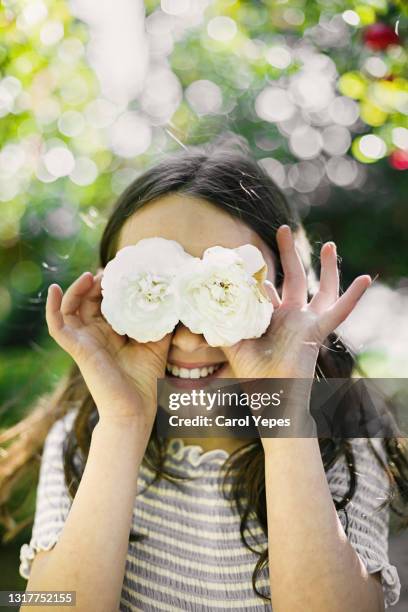 girl holding camellia white flower in front of eyes - audio visual stock-fotos und bilder