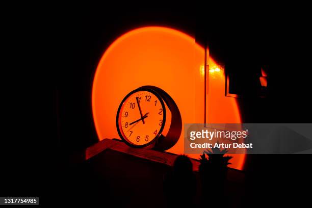 wall clock in office desk with big sunset sun light effect. - zeitstrahl stock-fotos und bilder