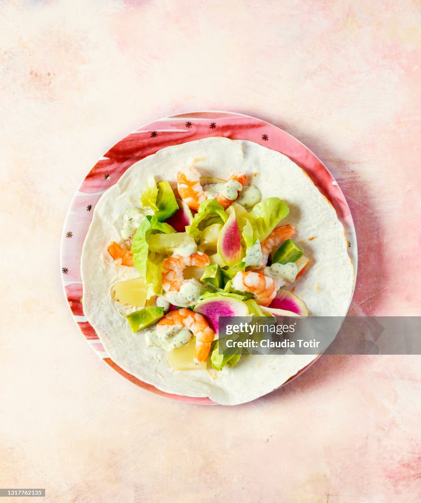 Shrimp tostada on peach background