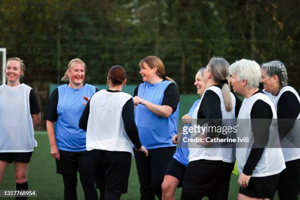 female footballers smile during training - community stock pictures, royalty-free photos & images
