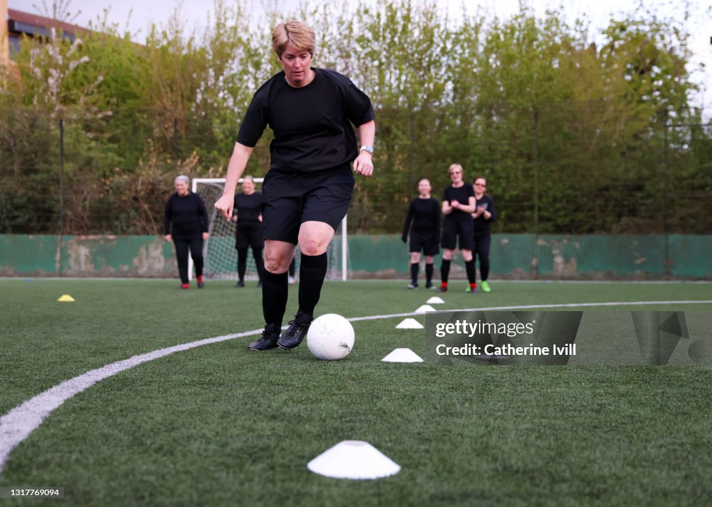 Woman dribbles ball during football practice