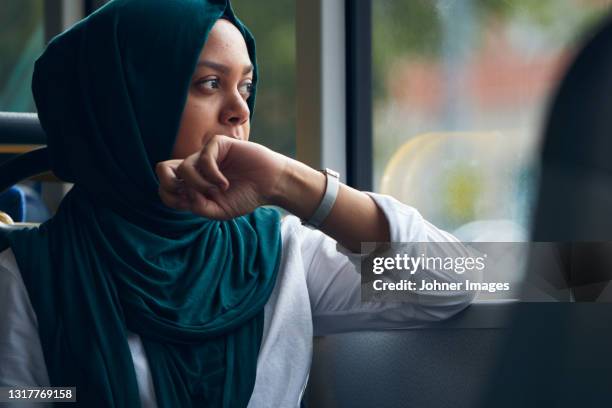 young woman in bus looking through window - veil imagens e fotografias de stock