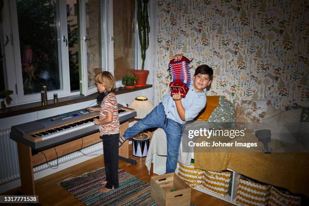 boys playing in bedroom - accordeon instrument stockfoto's en -beelden