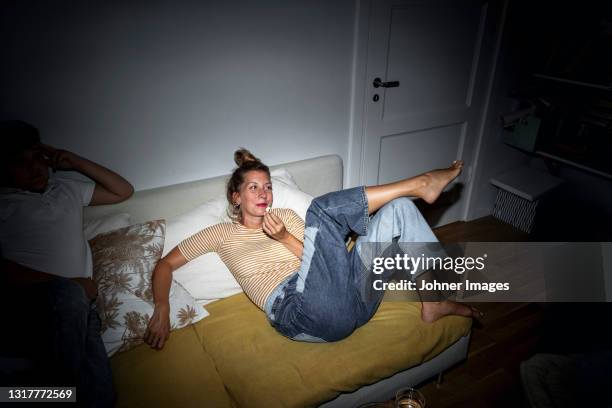 woman relaxing on sofa - jeans barefoot fotografías e imágenes de stock