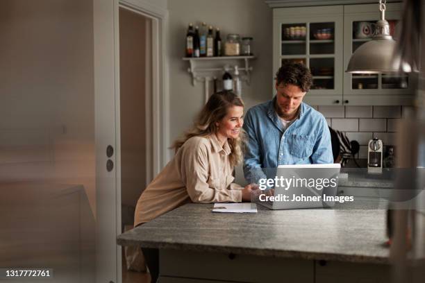 couple using laptop at home - women looking at laptop stock pictures, royalty-free photos & images