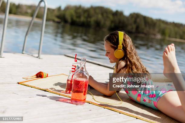 girl using digital tablet on jetty - standing water stock pictures, royalty-free photos & images