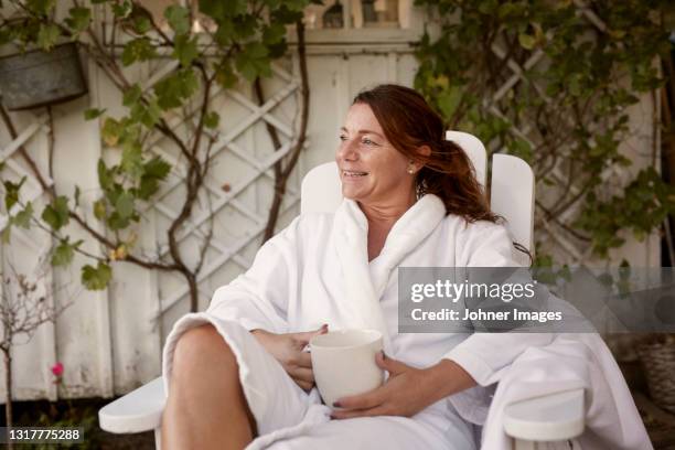 woman having coffee in garden - woman in bathrobe stock pictures, royalty-free photos & images