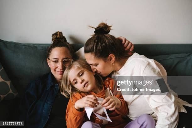 women with girl on sofa - gay fotografías e imágenes de stock