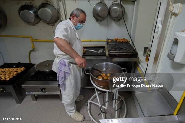 The pastry chef fries the typical San Isidro doughnuts at Casa Mira, on May 13, 2021 in Madrid, Spain. The different types of donuts such as the...