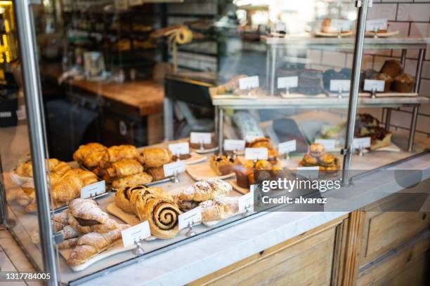 varios alimentos horneados en vitrina en panadería - escaparate fotografías e imágenes de stock